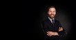 © wayhome.studio - Young handsome businessman in a suit with great smile against black background with lots of copy space.