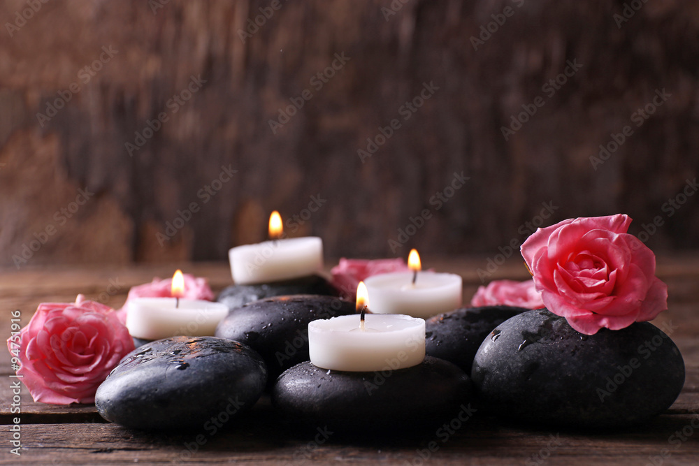 Tenderness relaxing composition with pebbles, roses and candles on wooden background