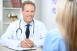 Smiling cardiologist talking to the patient 