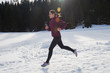 yougn woman jogging outdoor on snow in forest