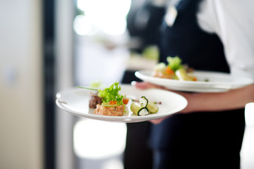 Waiter carrying plates with meat dish