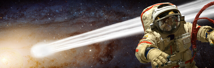 Wall Mural - a cosmonaut has a comet pass close to him - elements of this image furnished by nasa.