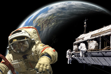 Wall Mural - a team of astronauts and cosmonauts perform work in space - elements of this image furnished by nasa