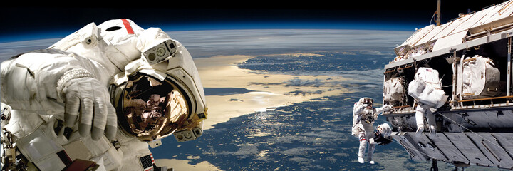 a team of astronauts performing work on a space station.- elements of this image furnished by nasa.