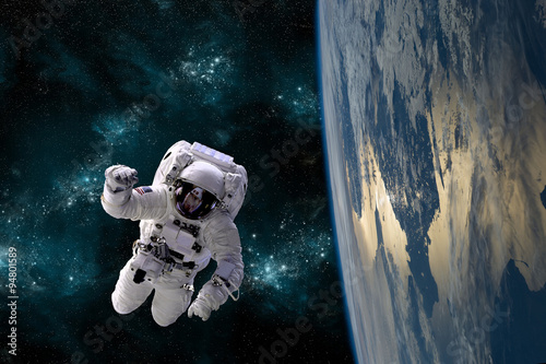 Fotografía Un astronauta flota en el ambiente de gravedad cero del espacio - elementos de esta imagen proporcionada por la NASA