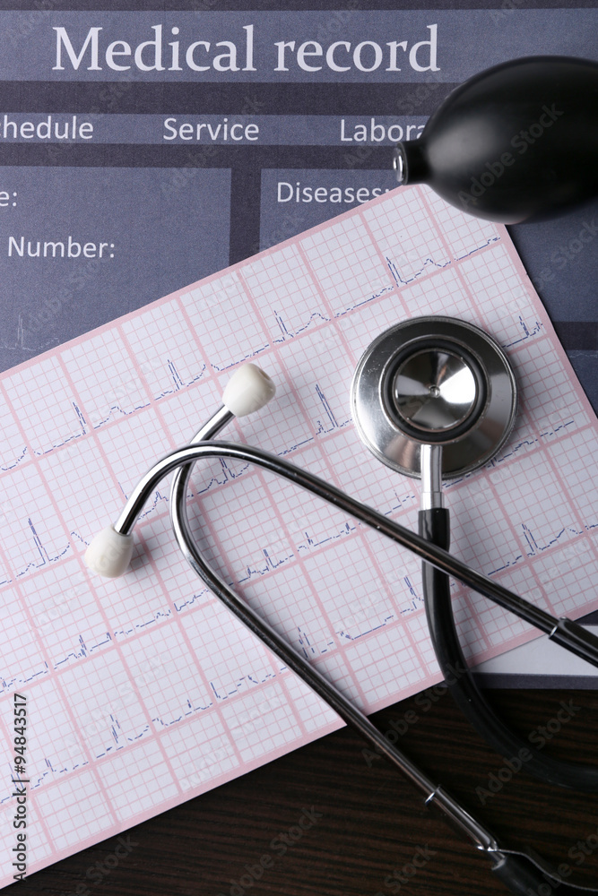 Blood pressure meter and stethoscope, on dark wooden background