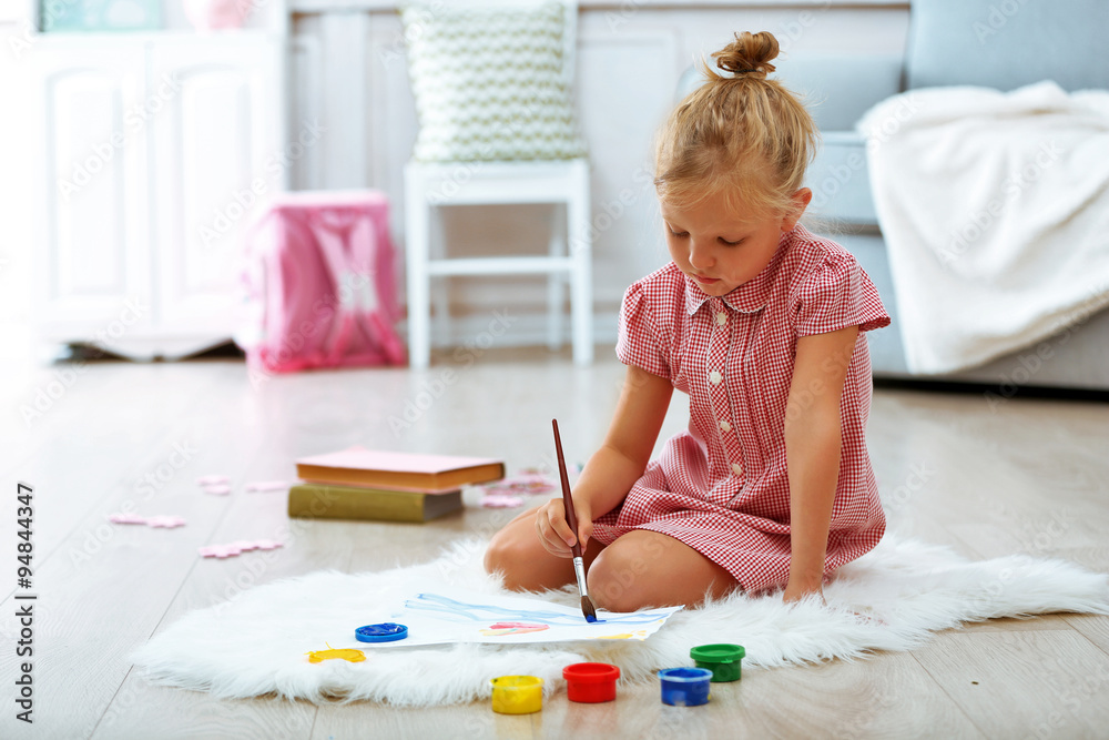 Little girl drawing in the room