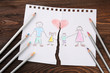 © Africa Studio - Torn apart drawing of a family on wooden background