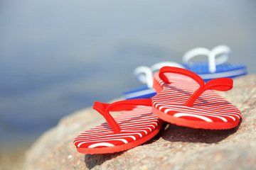 Sticker - Bright flip-flops on stone, nature background