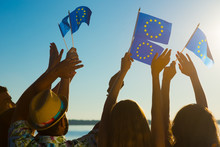 People With Raised Hands Waving Flags Of The European Union. 