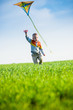 © mr.markin - Young boy playing with his kite in a green field.