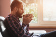 © Ivan Kruk - bearded man sitting with cup of morning coffee or tea