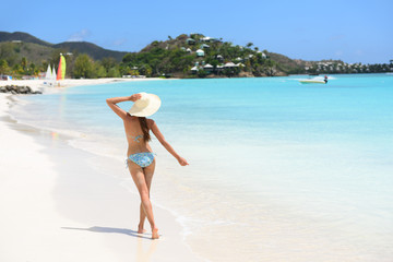 Beach travel woman bikini wearing sun hat walking