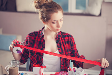 Wall Mural - Woman creating gift at home with paper and gouache