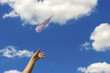 Throwing a paper airplane into the sky.