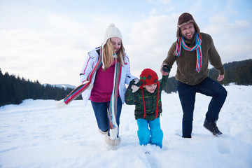 Canvas Print - happy family playing together in snow at winter