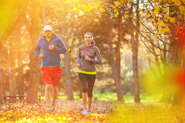 Man and female training outside during autumn day.