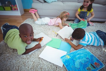 Wall Mural - Smiling kids drawing pictures on paper