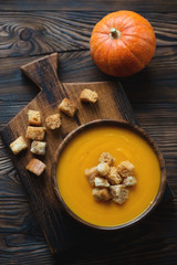 Sticker - Pumpkin cream-soup with croutons on a wooden cutting board