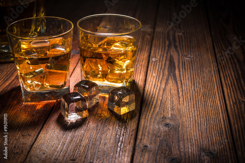 Fotografie, Obraz Dvě sklenice whisky s ledem na dřevěném stole