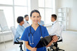 © Syda Productions - happy doctor with clipboard over group of medics