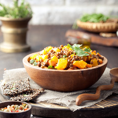 Wall Mural - Lentil with carrot and pumpkin ragout in a wooden bowl.