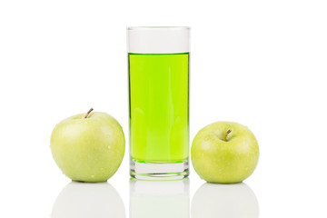 Green juice standing between two green apples with water drops on surface on white background.