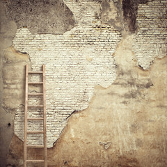 weathered stucco wall with wooden ladder