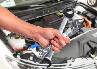 Hand of car mechanic in auto repair service. 