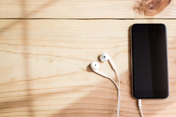 Aufkleber - phone and headphone on wood background