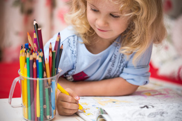portrait of child girl drawing with colorful pencils