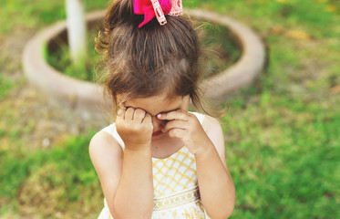 Cute little girl is crying outdoors