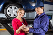 Customer Signing Document With Mechanic In Garage