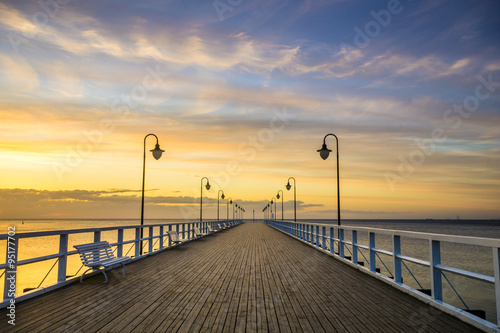 Naklejka na meble wooden pier by the sea lit by stylish lamps at night 