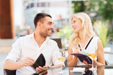 Poster - happy couple with wallet paying bill at restaurant