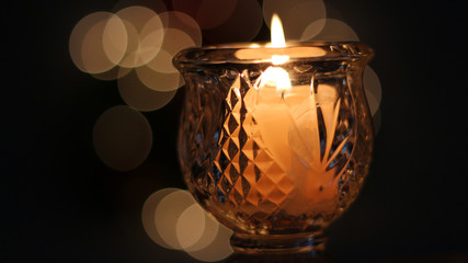 Flickering candle with Christmas light bokeh