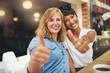 © Flamingo Images - Two happy young female friends giving a thumbs up