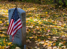 Gravestone From A War Veteran With An American Flag 
