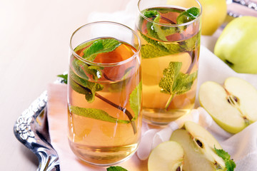 Canvas Print - Glasses of apple juice with fruits and fresh mint on table close up