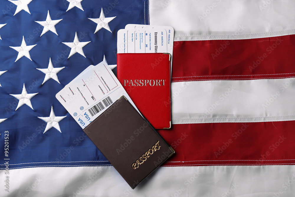 Passports, tickets lying on American Flag background