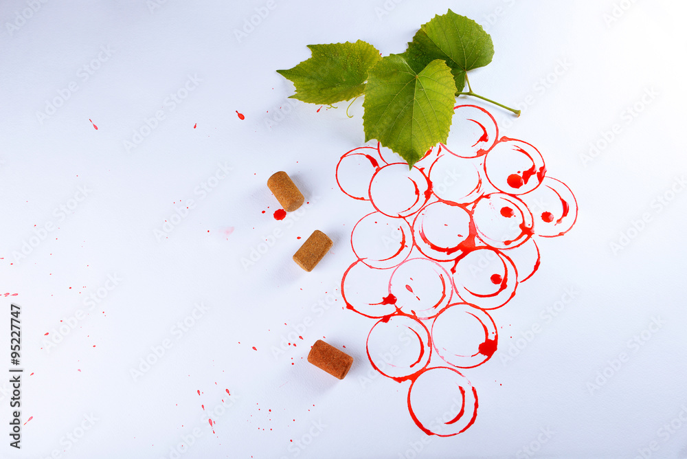 Grapes painted with red wine and cork isolated on white