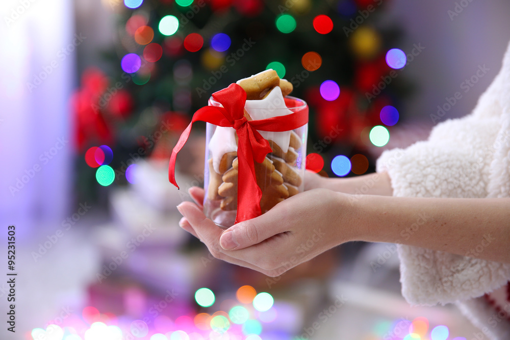 Female hands holding jar with Christmas cookies