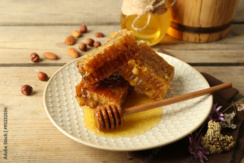 Honeycombs on plate on wooden background