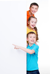 Group of children pointing on white banner.