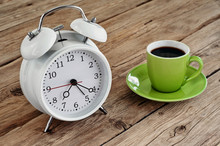 Green Cup Of Espresso With An White Alarm Clock