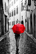 © Photocreo Bednarek - Woman with red umbrella on retro street in the old town. Wind and rain