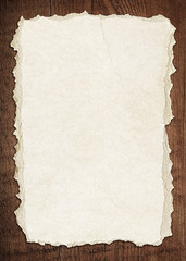 Wall Mural - light brown torn paper is on old wooden board