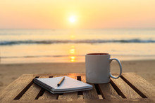 Coffee Cup On Wood Table At Sunset Or Sunrise Beach