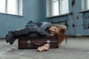 Lonely girl sitting on the suitcase 