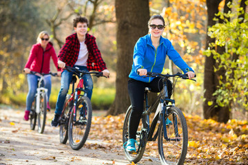 Wall Mural - Healthy lifestyle - people riding bicycles in city park